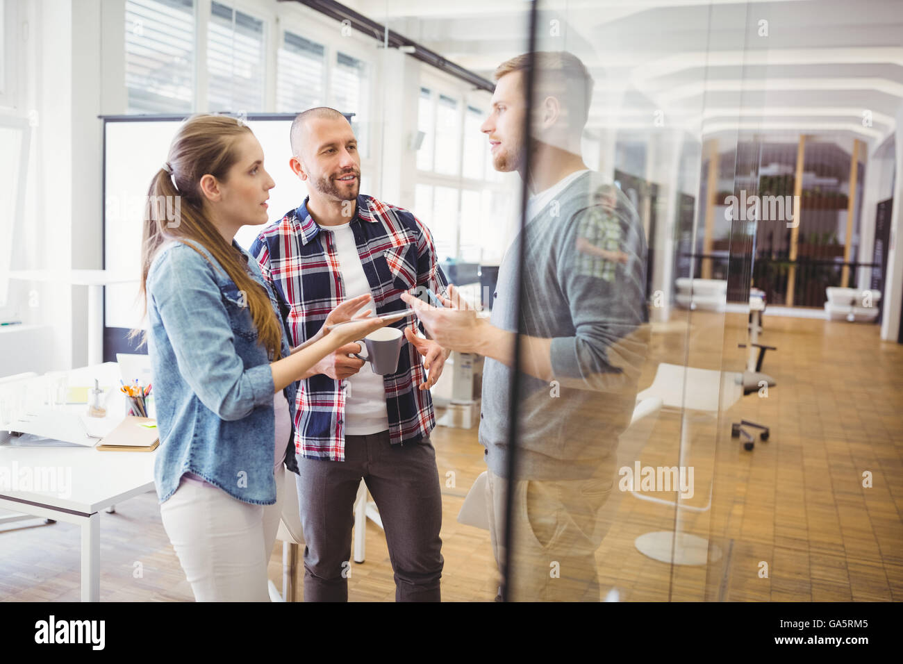 Imprenditrice a discutere con i colleghi in ufficio Foto Stock