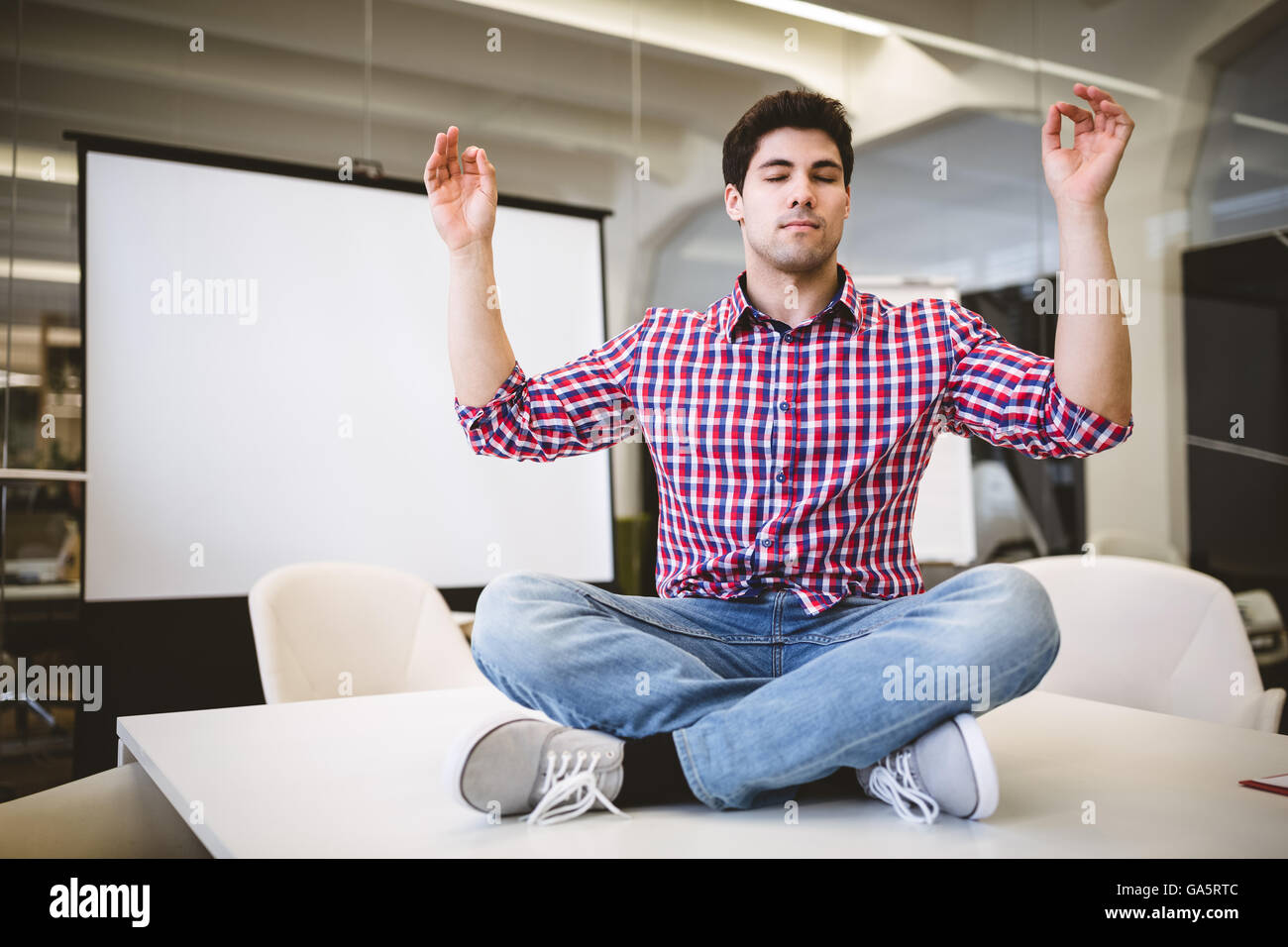 Imprenditore esecuzione di yoga nella sala riunioni Foto Stock