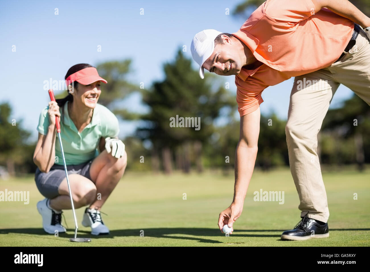 Ritratto di uomo rimozione pallina da golf dal foro Foto Stock