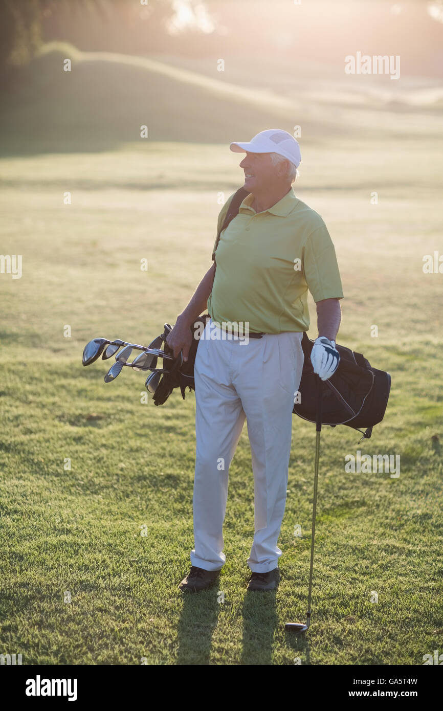 Lunghezza completa di uomo maturo che trasportano borsa da golf Foto Stock