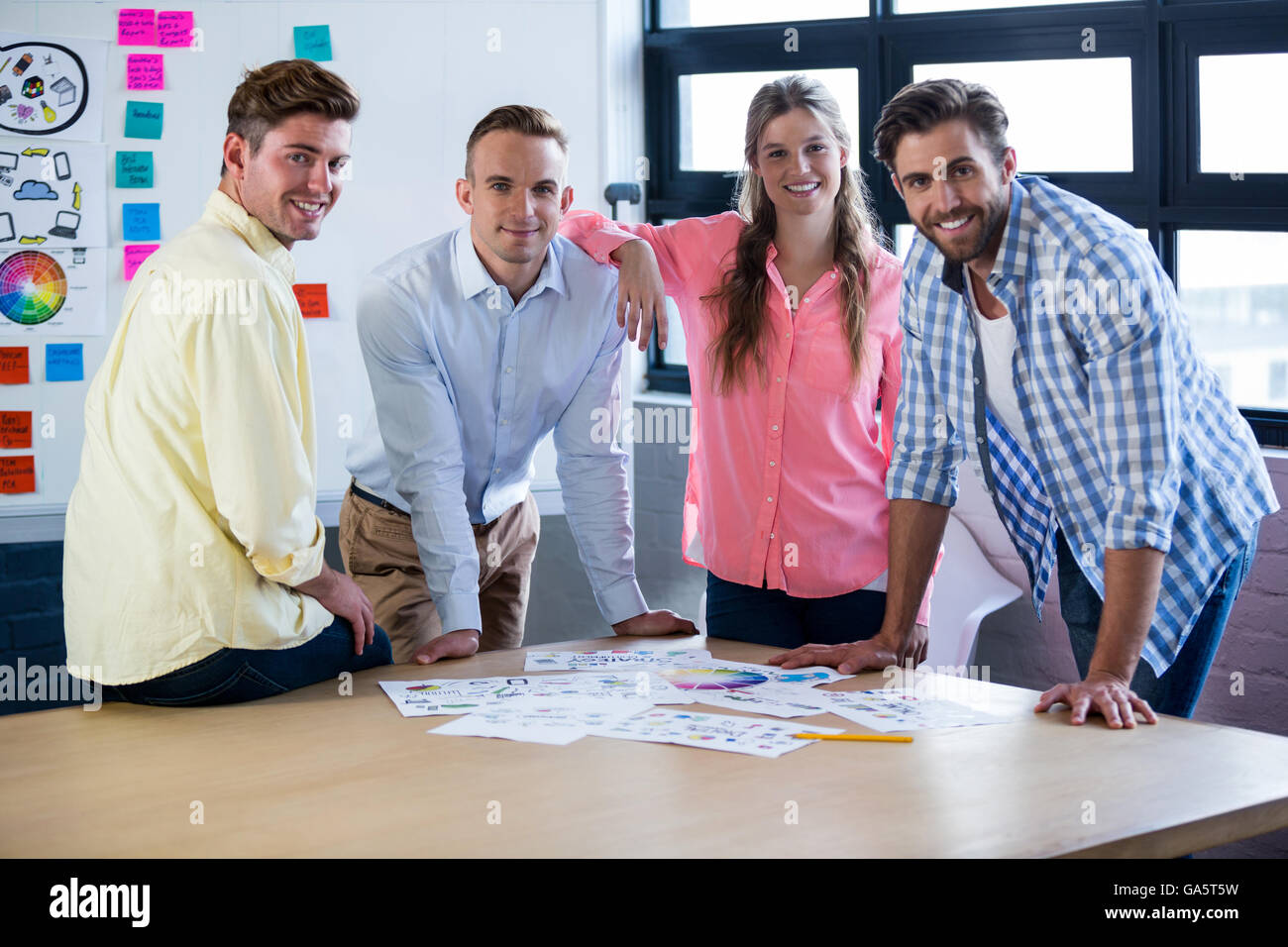 Business persone sorridenti mentre in piedi dalla tabella Foto Stock