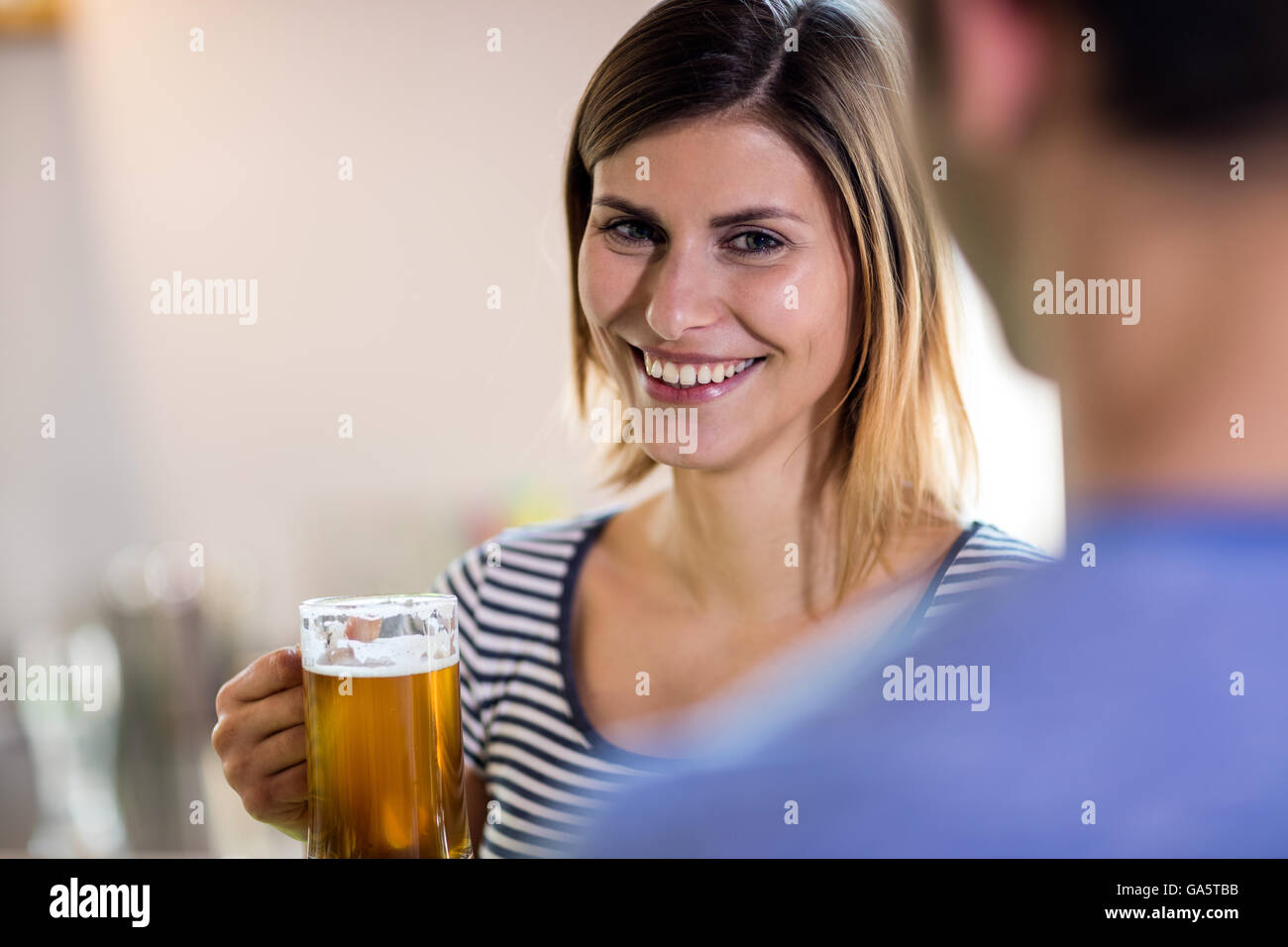 Sorridente giovane donna azienda boccale di birra Foto Stock