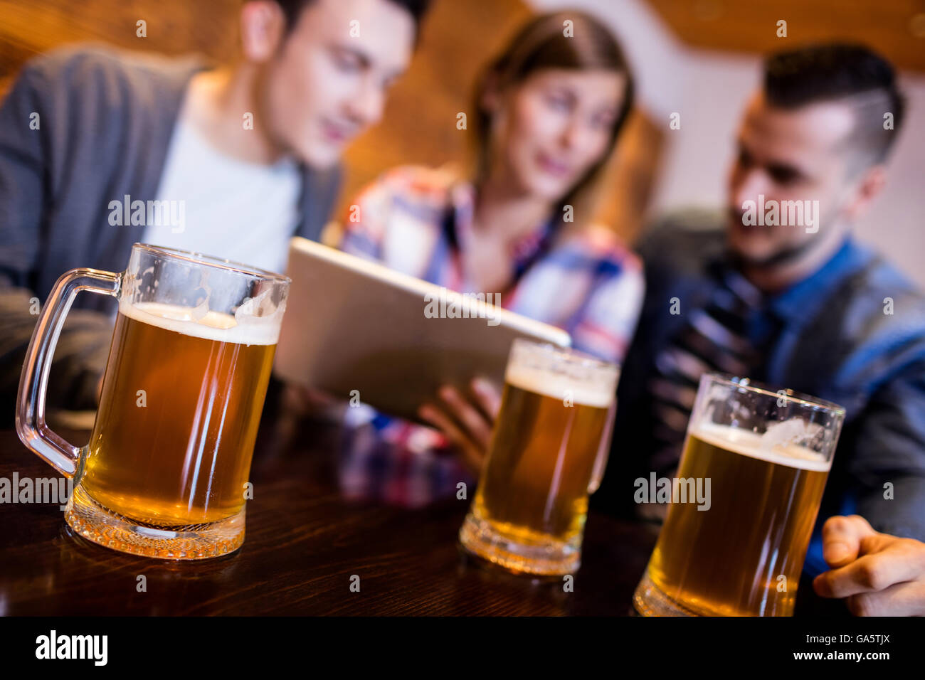 Boccali da birra con gli amici presso il ristorante Foto Stock