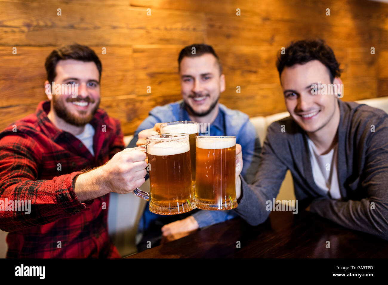 Ritratto di amici maschi la tostatura la birra al ristorante Foto Stock