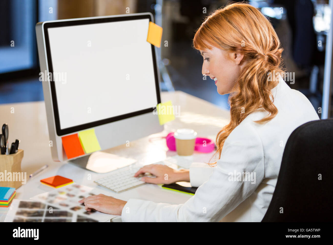 Femmina editor foto lavora al computer desk Foto Stock
