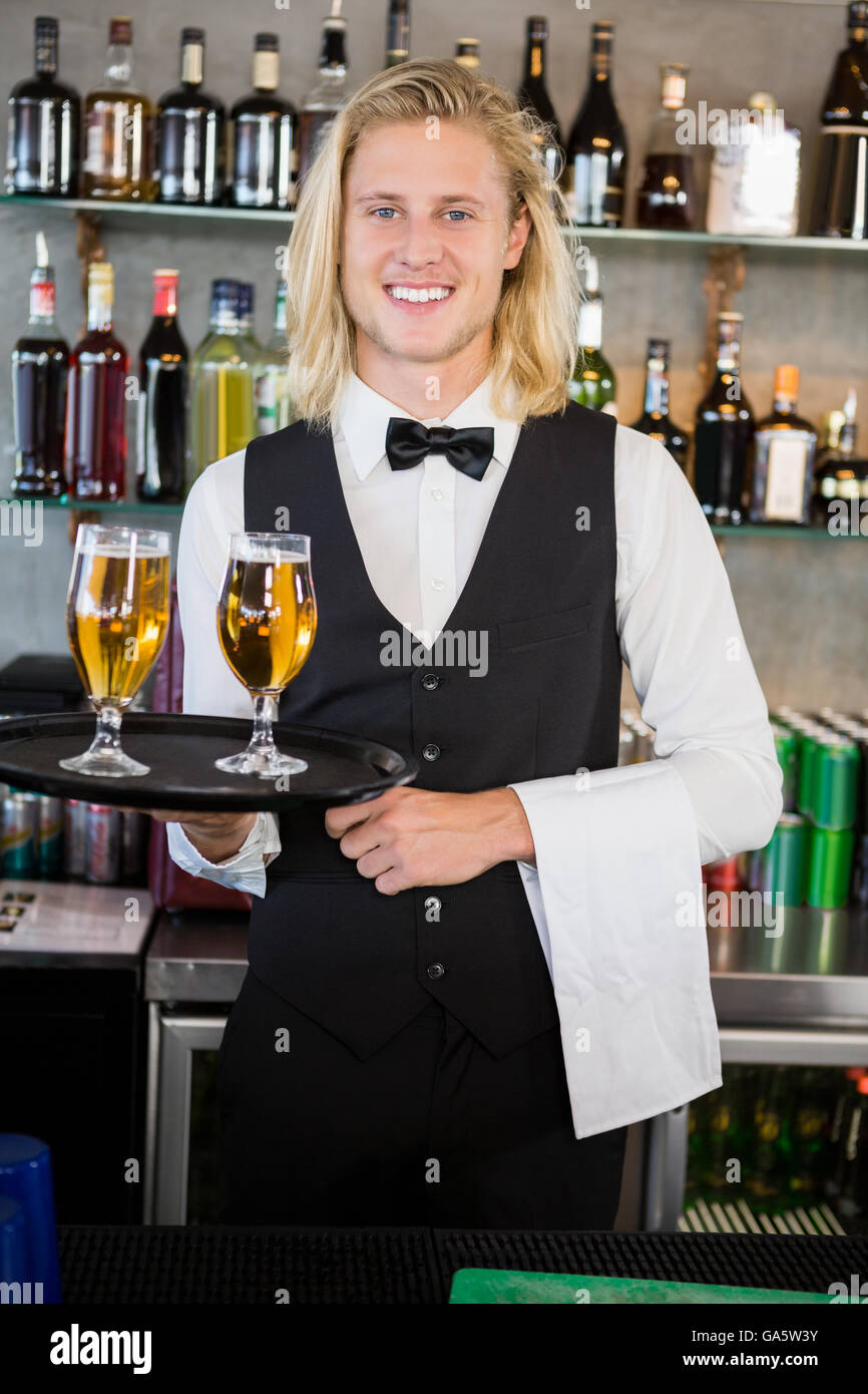 Ritratto di cameriere tenendo il vassoio con i bicchieri di birra Foto Stock