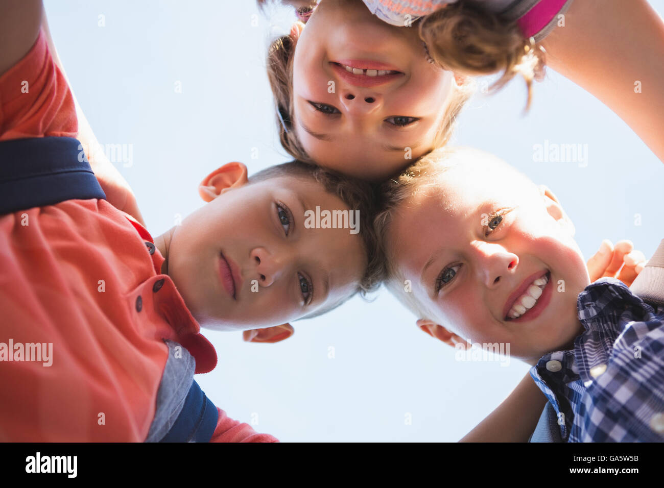 Formazione Schoolkids huddle in campus Foto Stock