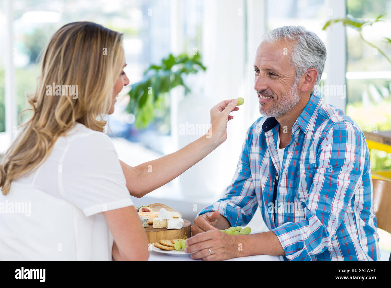 Donna uve di alimentazione al marito Foto Stock