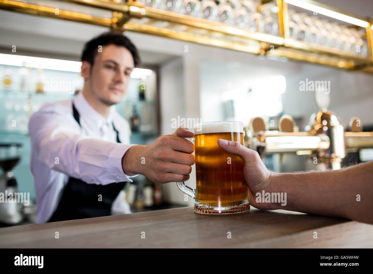 Barman che serve birra per il cliente Foto Stock