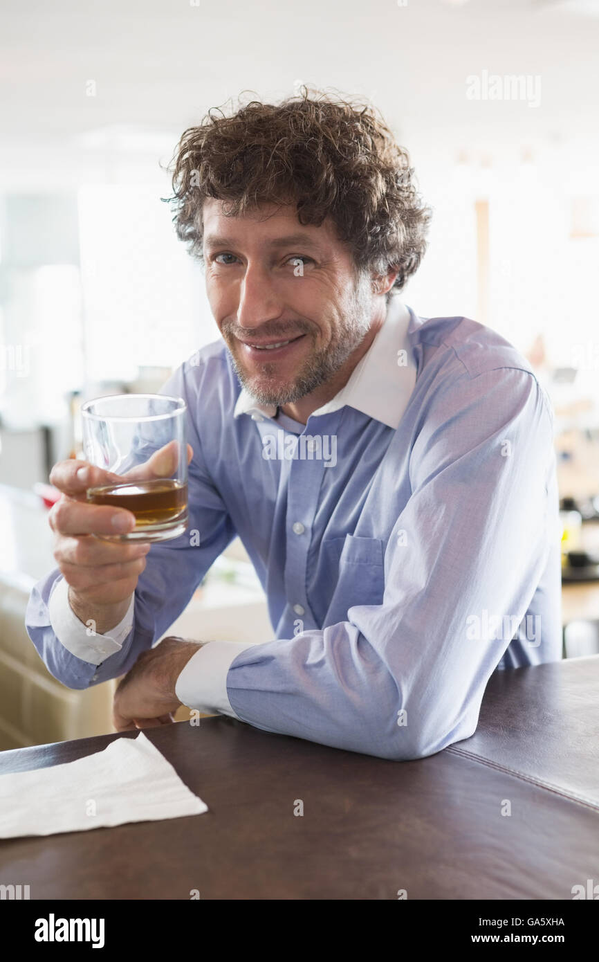 Uomo felice con in mano un bicchiere di alcool Foto Stock