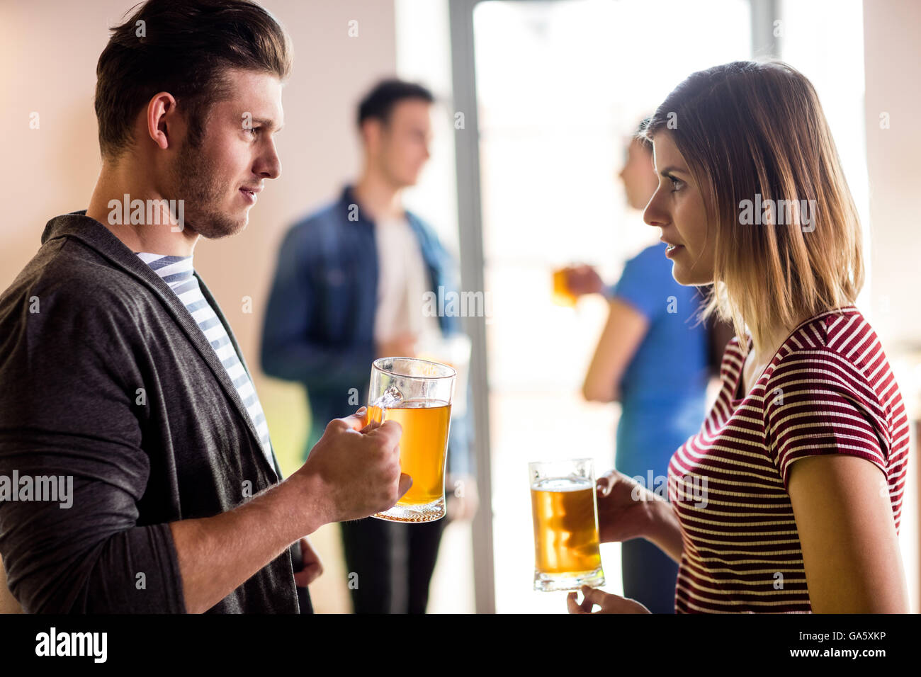 Coppia giovane con boccale di birra in bar Foto Stock
