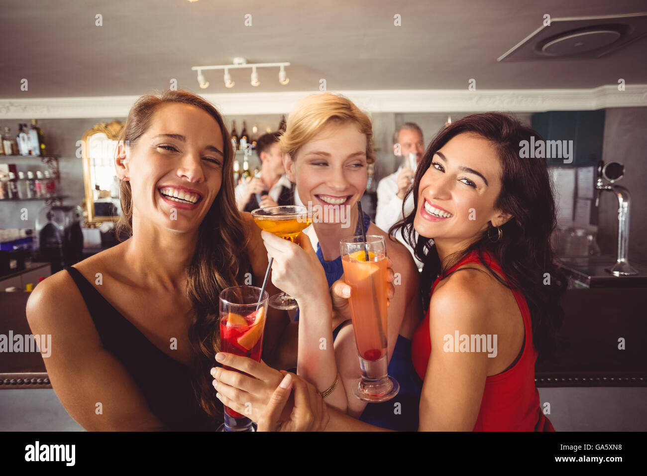 Happy amici di sesso femminile tenendo un bicchiere di cocktail Foto Stock