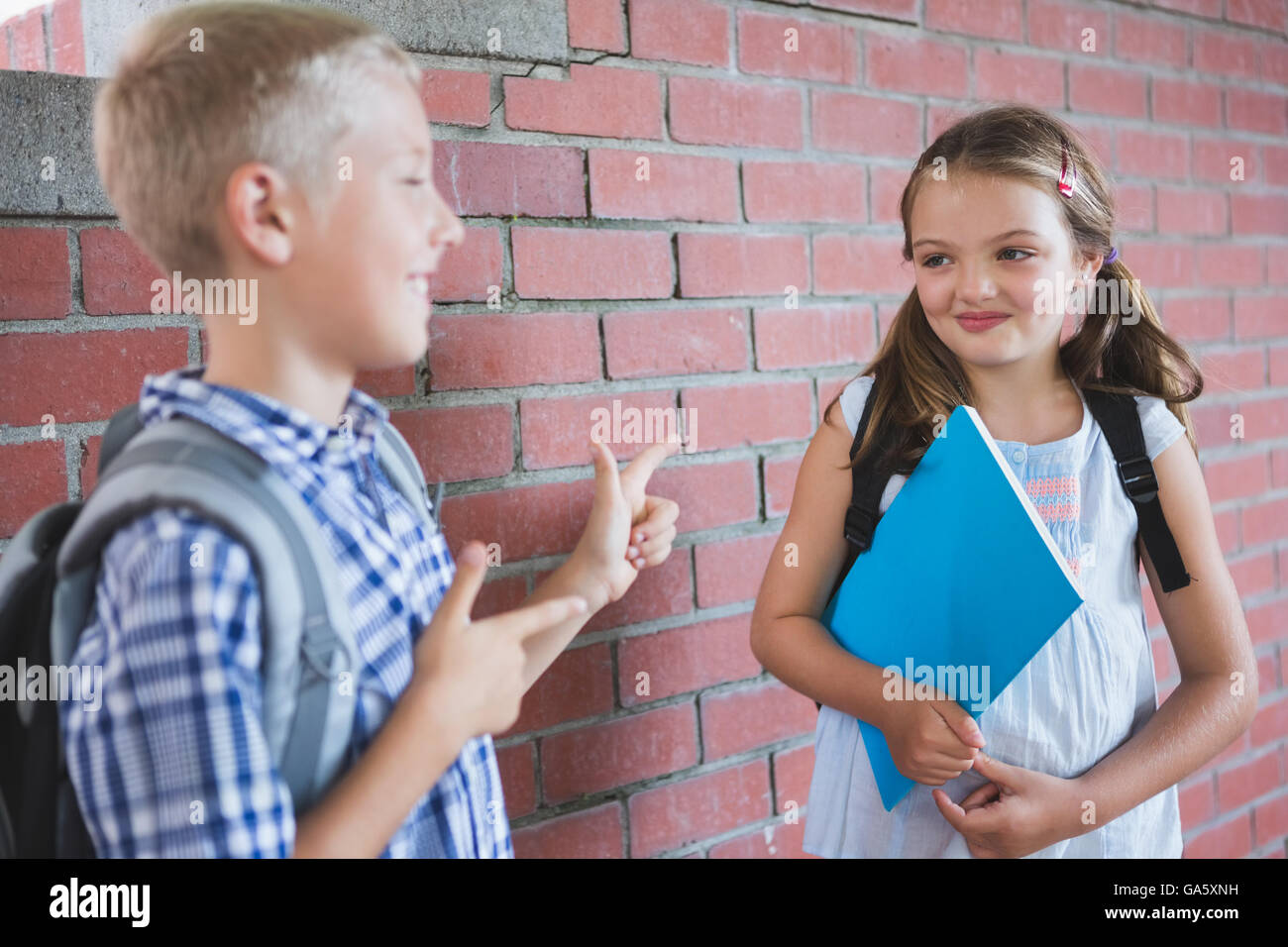 Schoolkids parlando a ogni altra in corridoio Foto Stock