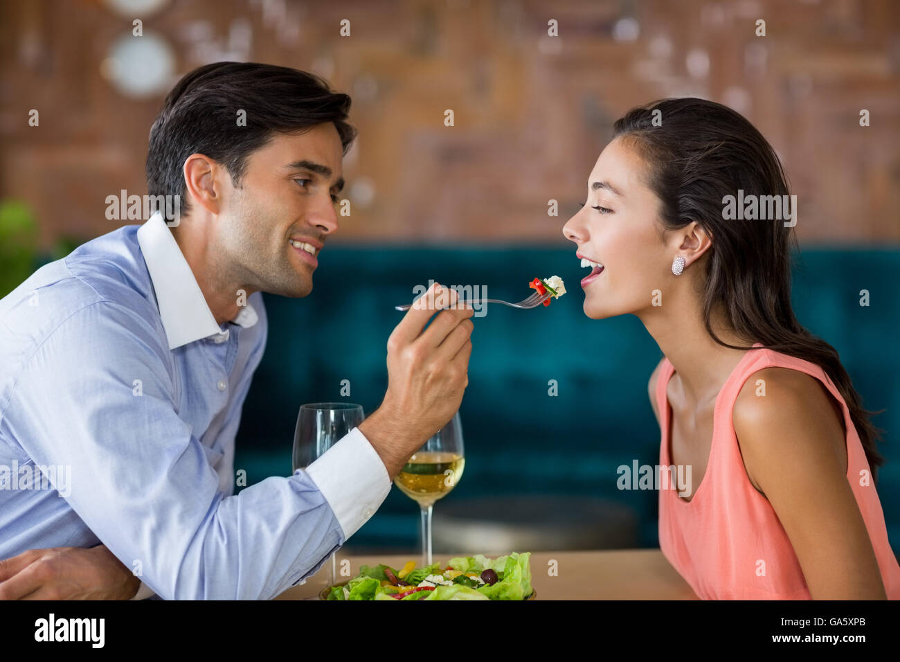 Uomo sorridente pasto di alimentazione per donna Foto Stock