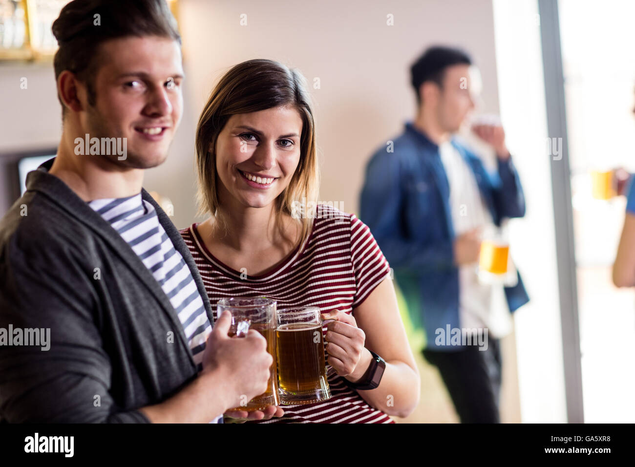Felice coppia giovane con boccale di birra Foto Stock
