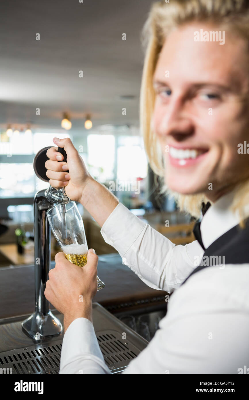 Cameriere il riempimento di una birra dal bar pompa Foto Stock