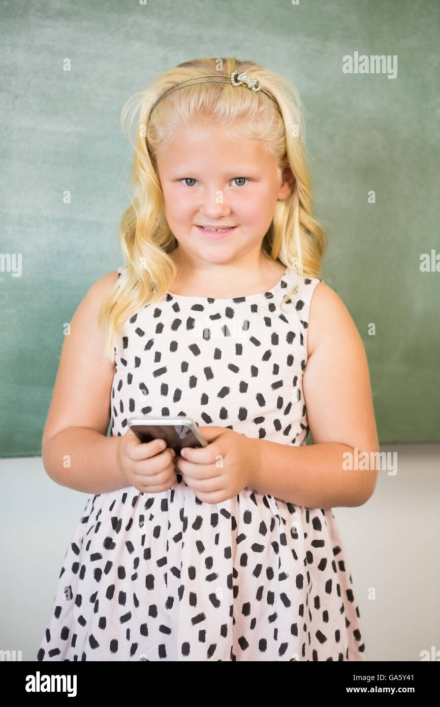 Schoolgirl utilizzando il telefono cellulare in aula Foto Stock