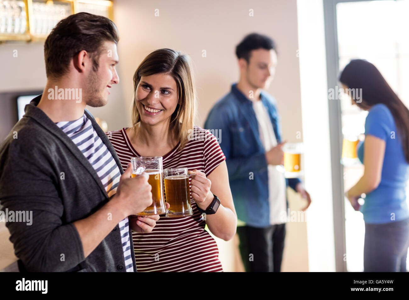 Coppia con boccale di birra in bar Foto Stock