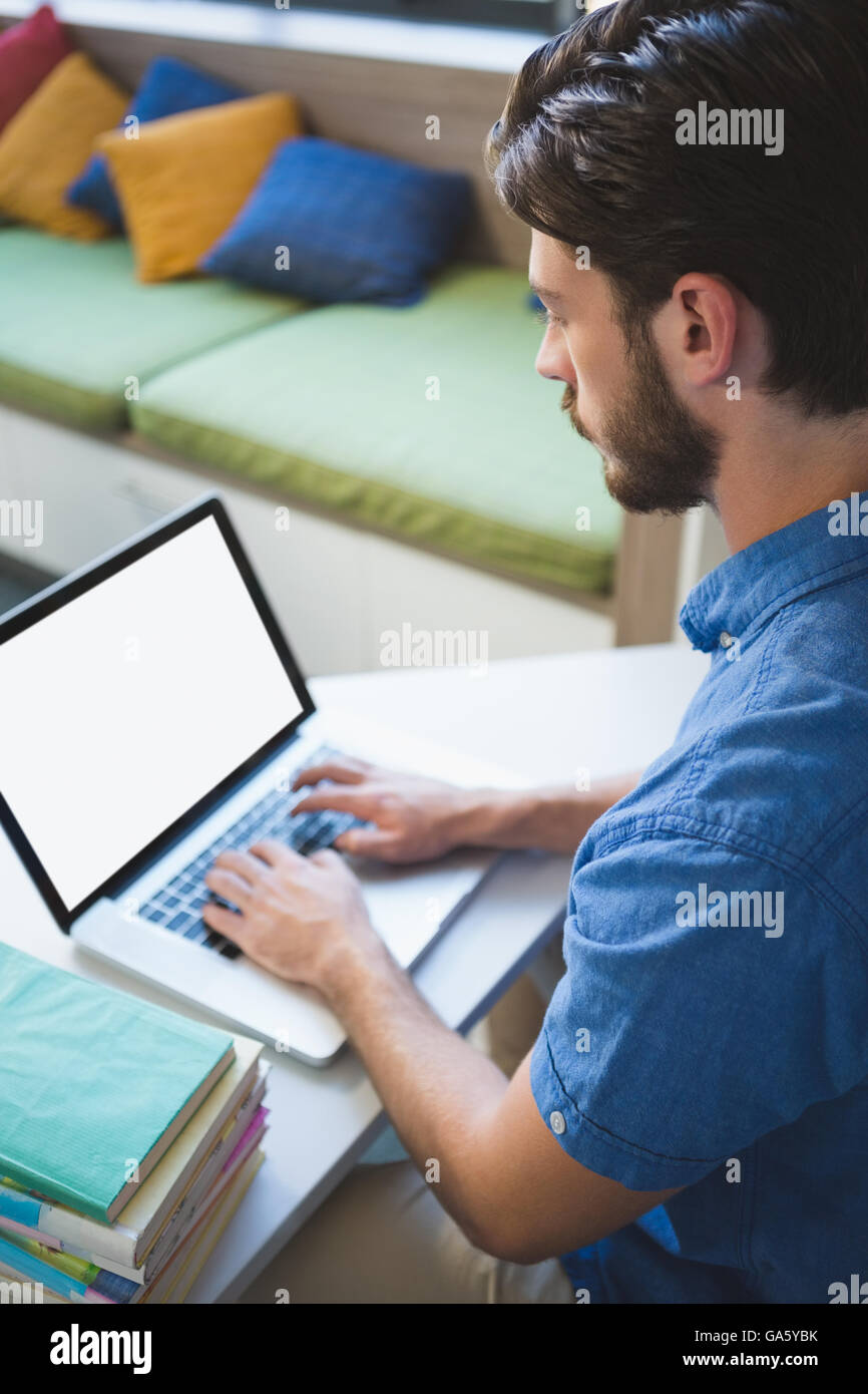 Un insegnante di lavorare sul computer portatile in biblioteca Foto Stock