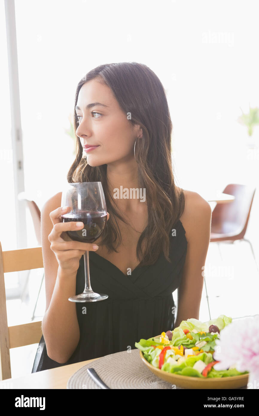 Bella donna avente il vino con pasto Foto Stock