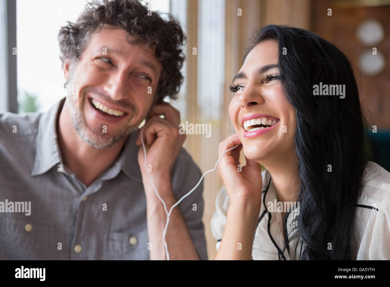 Giovane ascoltando musica insieme nella caffetteria Foto Stock