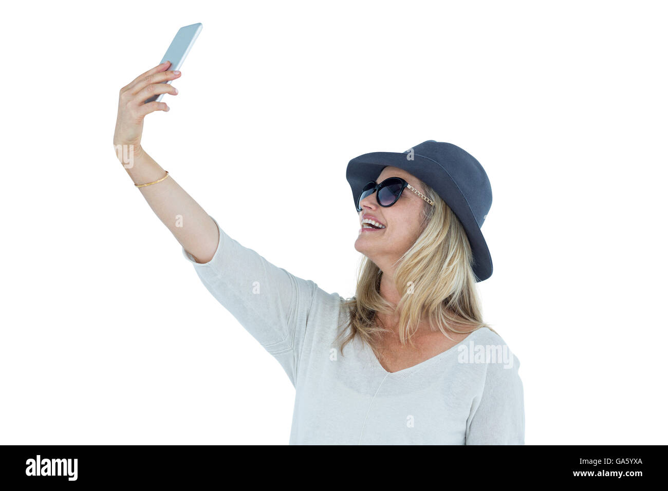 Donna prendendo selfie contro uno sfondo bianco Foto Stock