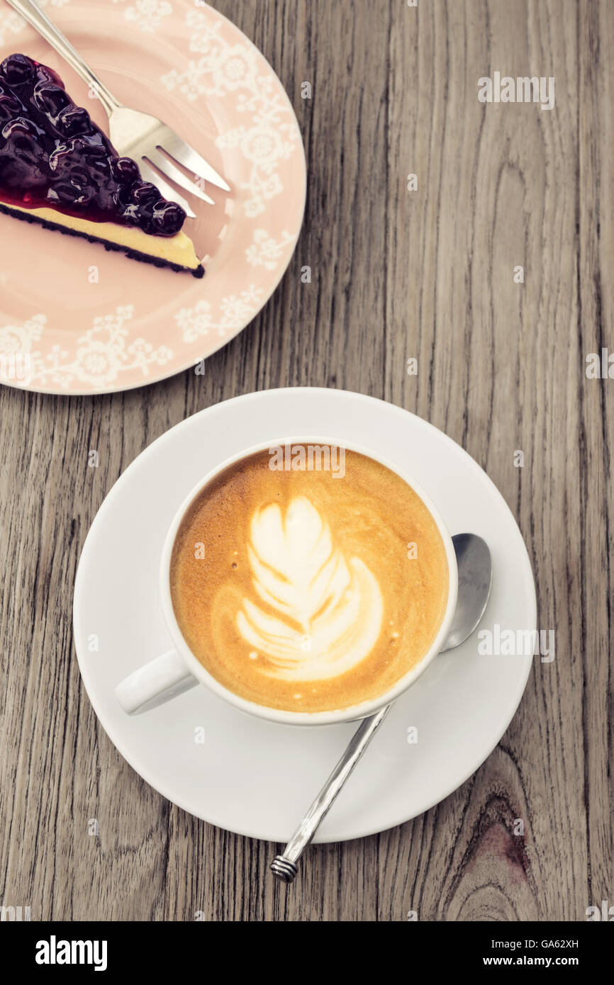 Caffè caldo latte con blue berry cheese cake lifestyle leisure sul tavolo di legno Foto Stock