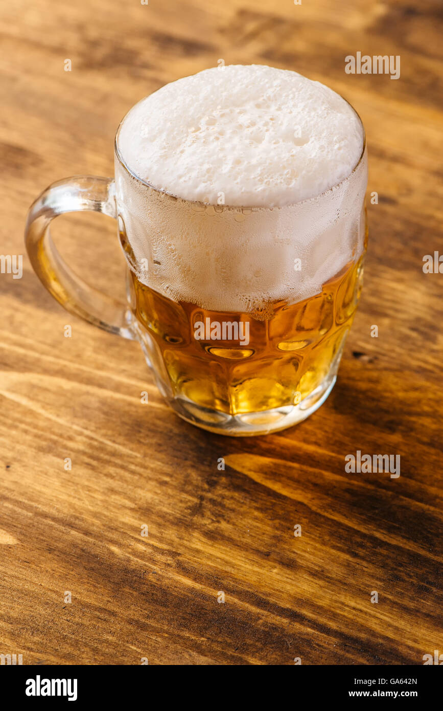 Boccale di birra piena di freddo fresco drink alcolici su sfondo di legno, fuoco selettivo Foto Stock