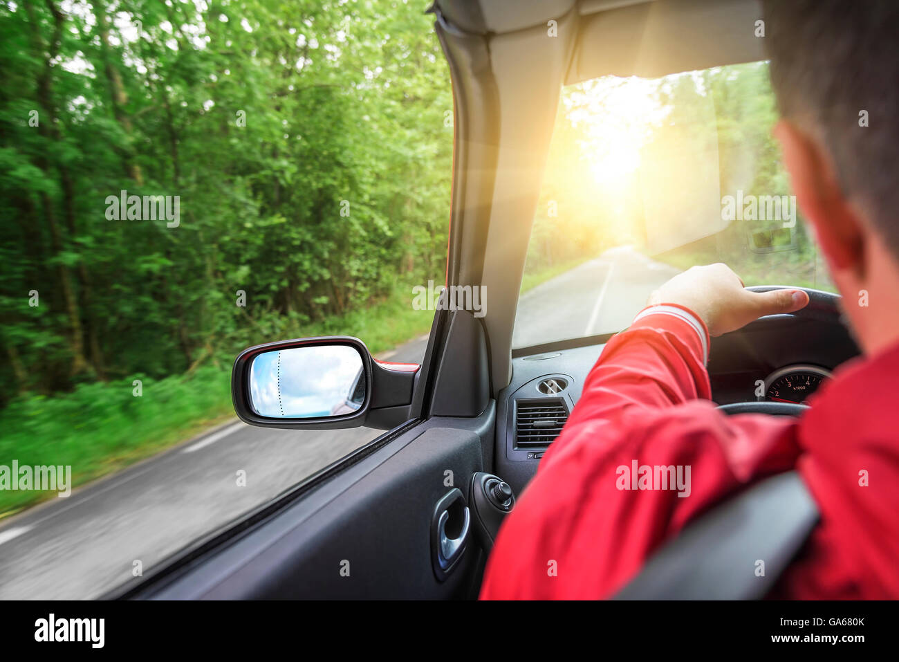 Driver maschio aziona una autovettura convertibile sulla strada del paese. La vista dalla cabina, vista posteriore, all'interno. Foto Stock