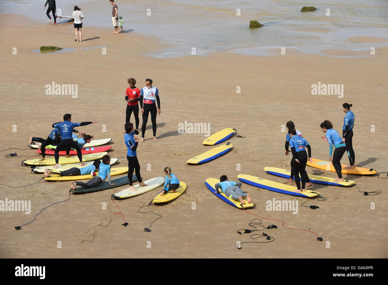 Surfers scuola di surf lezione con la tavola da surf a Biarritz Francia Foto Stock