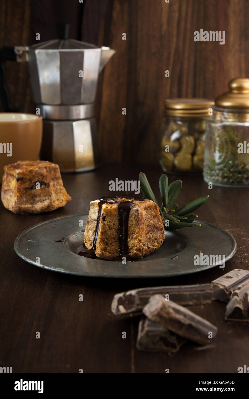 Close-up di torta con cioccolato fondente versando sulla piastra su una tavola in legno rustico Foto Stock