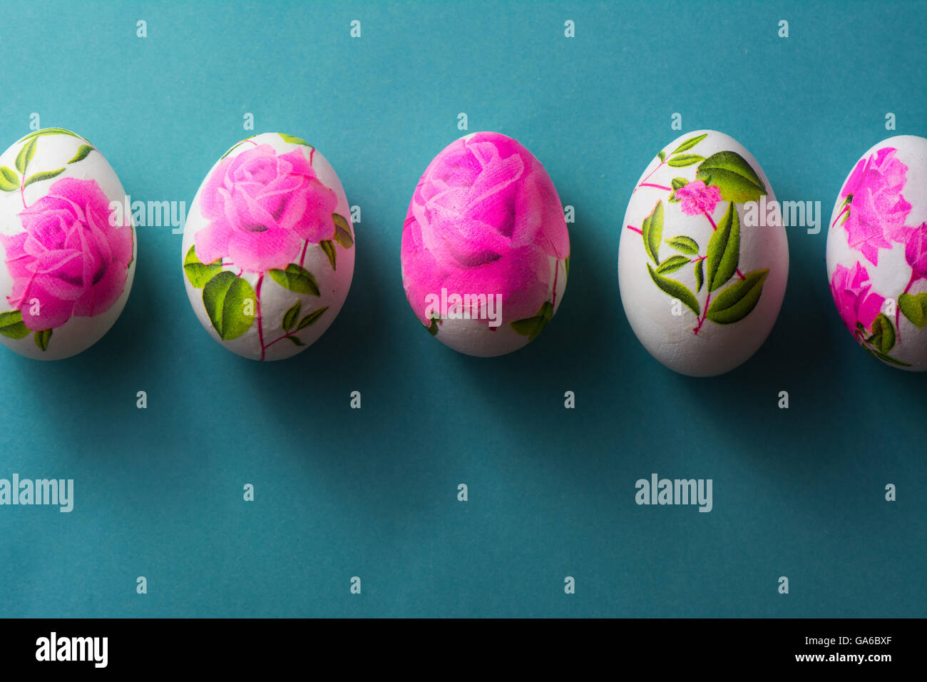 Decoupage uova di Pasqua decorate con fiori di tovaglioli di carta e  bloccato con colla, om sfondo blu. sopra visualizza Foto stock - Alamy
