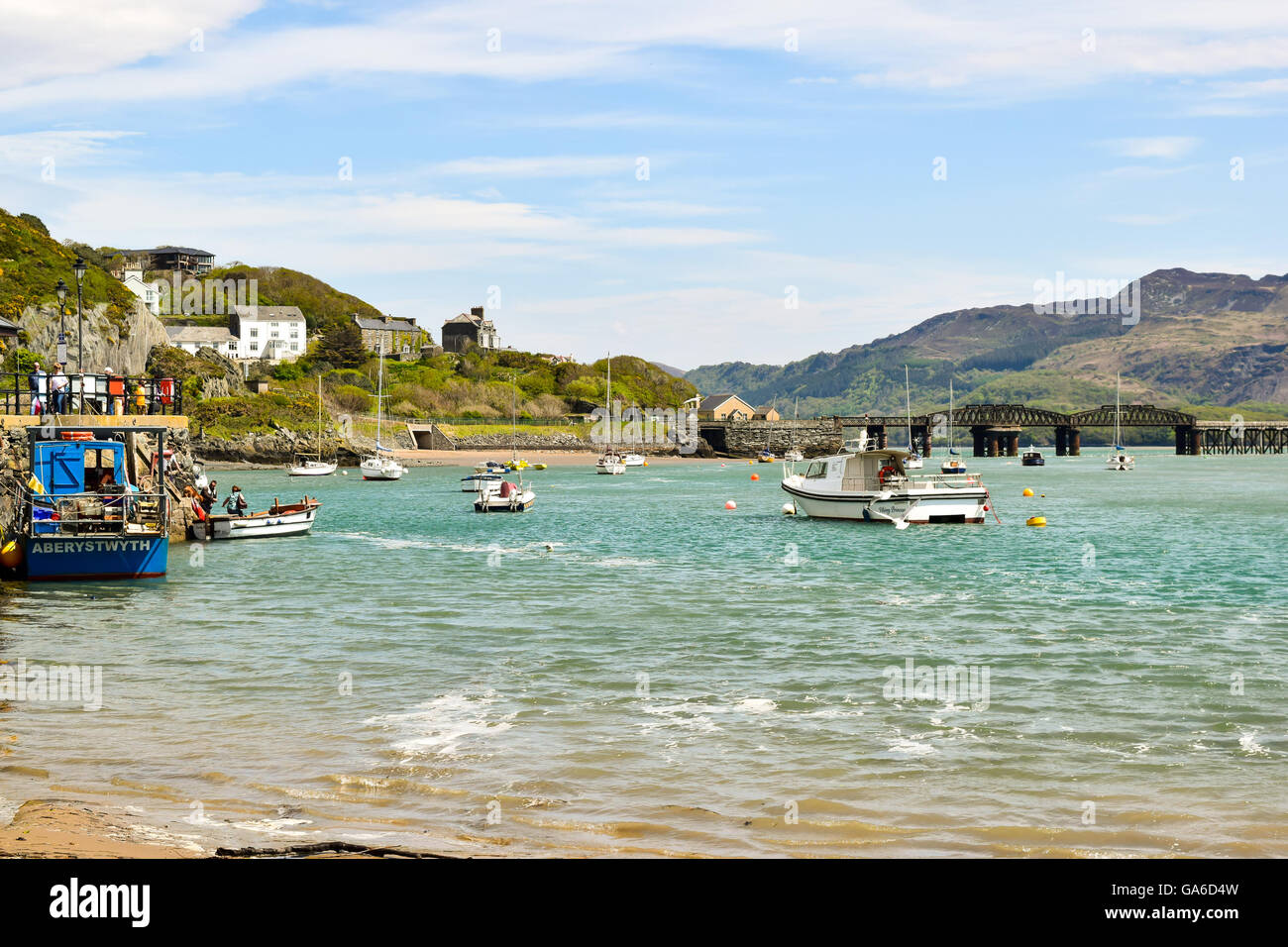Barche nel porto di Barmouth con ponte ferroviario in background. Foto Stock