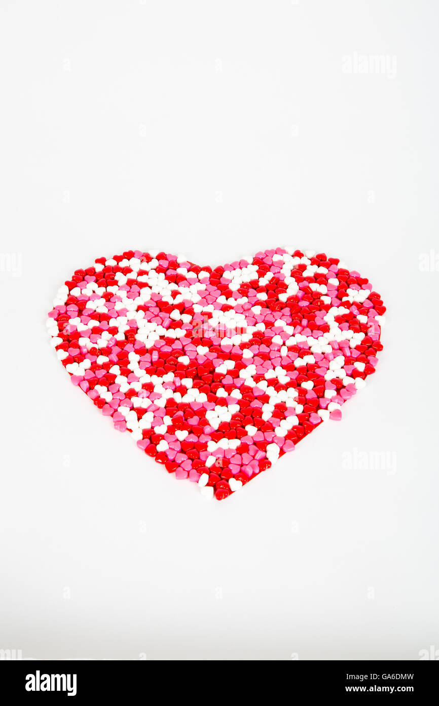 Rosso, bianco e rosa candy cuori per il giorno di San Valentino, arrainged in un grande cuore su sfondo bianco Foto Stock