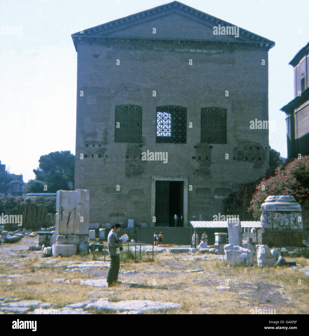 Questa 1970 foto mostra la curia, o Senato Romano House, nel Foro Romano a Roma, Italia. Esso risale al tempo di Giulio Cesare e fu costruito il anno del suo assassinio - 44 A.C. A causa dell'assassinio, la costruzione è stata interrotta. Essa è stata completata sotto Cesare il successore di Augusto -- nel 29 A.C. Si trova qui, sotto la lamiera ondulata per copertura a sinistra di fronte alla curia, è il Lapis niger, un antico santuario che è stato creduto per risalire al tempo in cui i re governato Roma (Repubblica iniziato nel 509 a.C.). Foto Stock