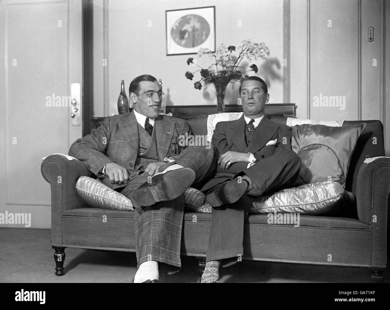 Il pugile italiano primo Carnera (a sinistra) incontra l'attore francese Maurice Chevalier. Foto Stock