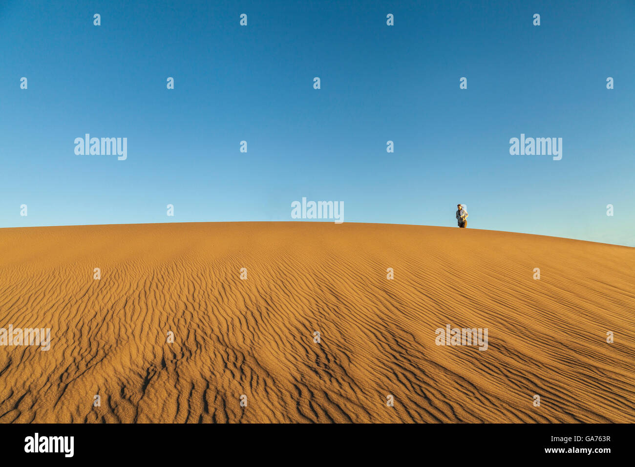 Donna che cammina sulla sommità del Mesquite dune di sabbia nel Parco Nazionale della Valle della Morte, CALIFORNIA, STATI UNITI D'AMERICA Foto Stock