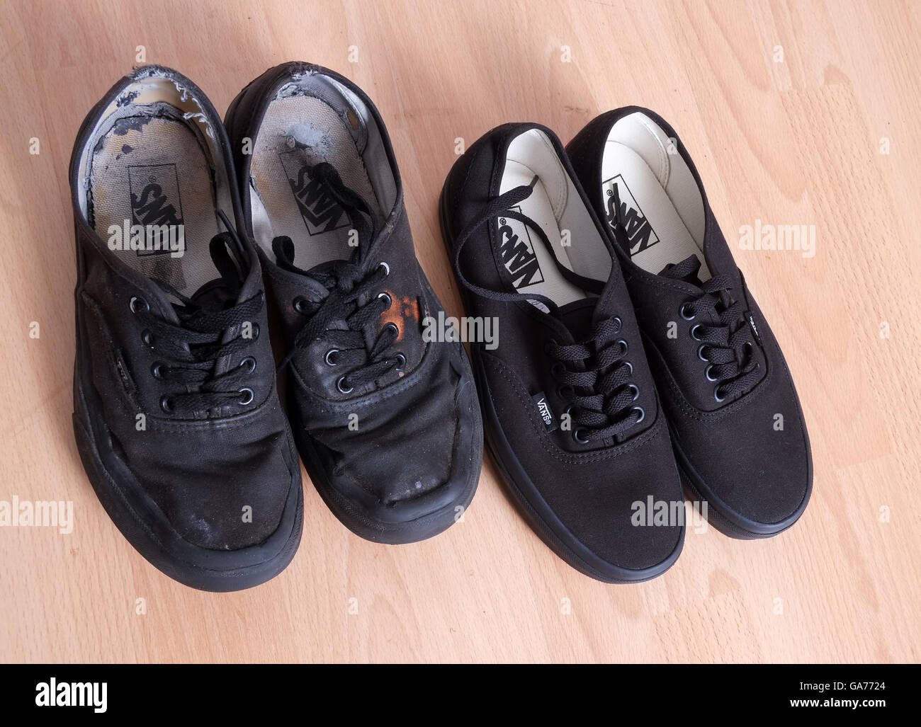 Nuovo e vecchio nero sneakers o formatori, utilizzato da una cameriera in un affollato bar o ristorante. Luglio 2016 Foto Stock