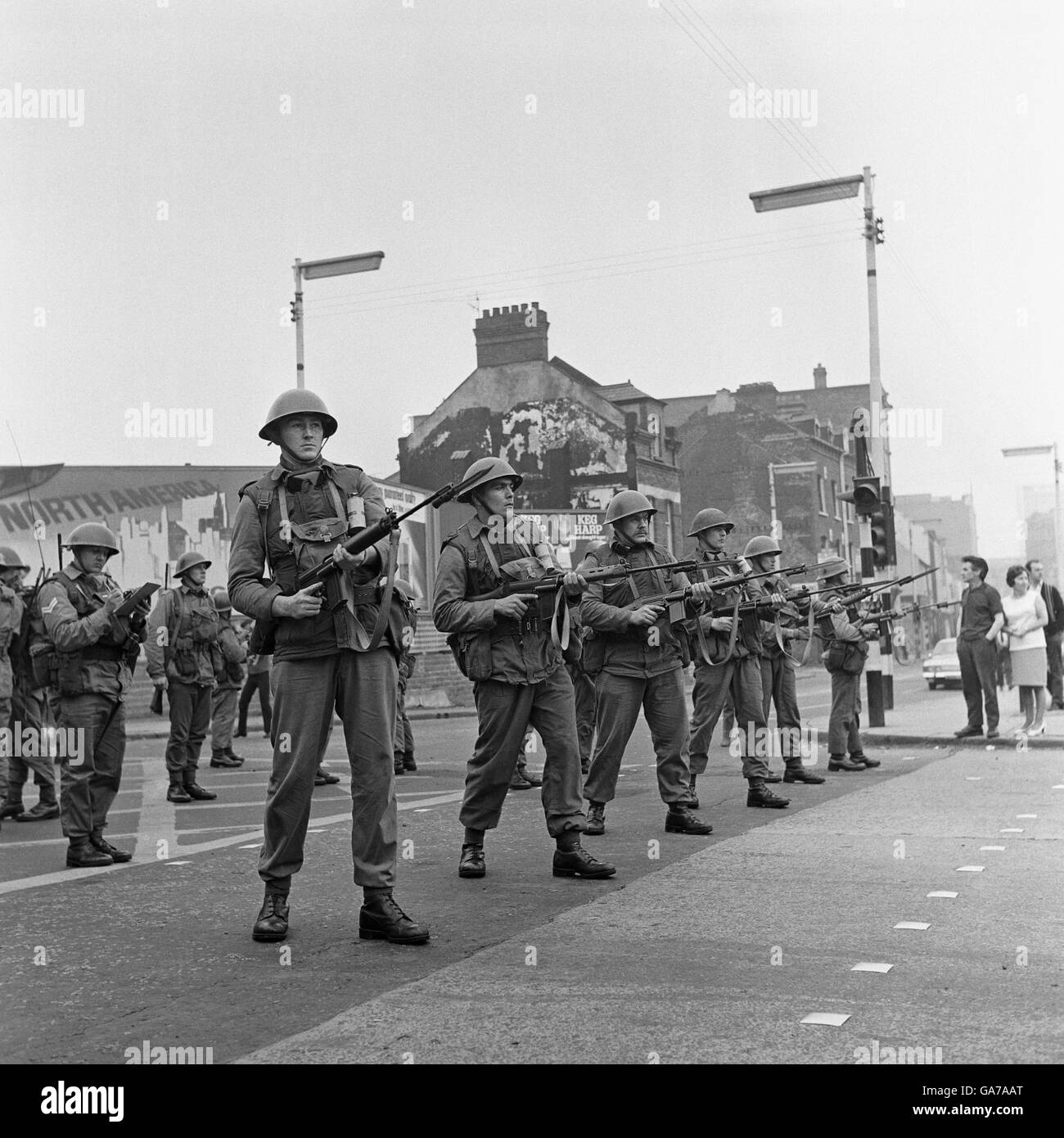 Una linea di truppe britanniche si levano in piedi in guardia nella zona di Falls Road di Belfast strappato riot. Foto Stock