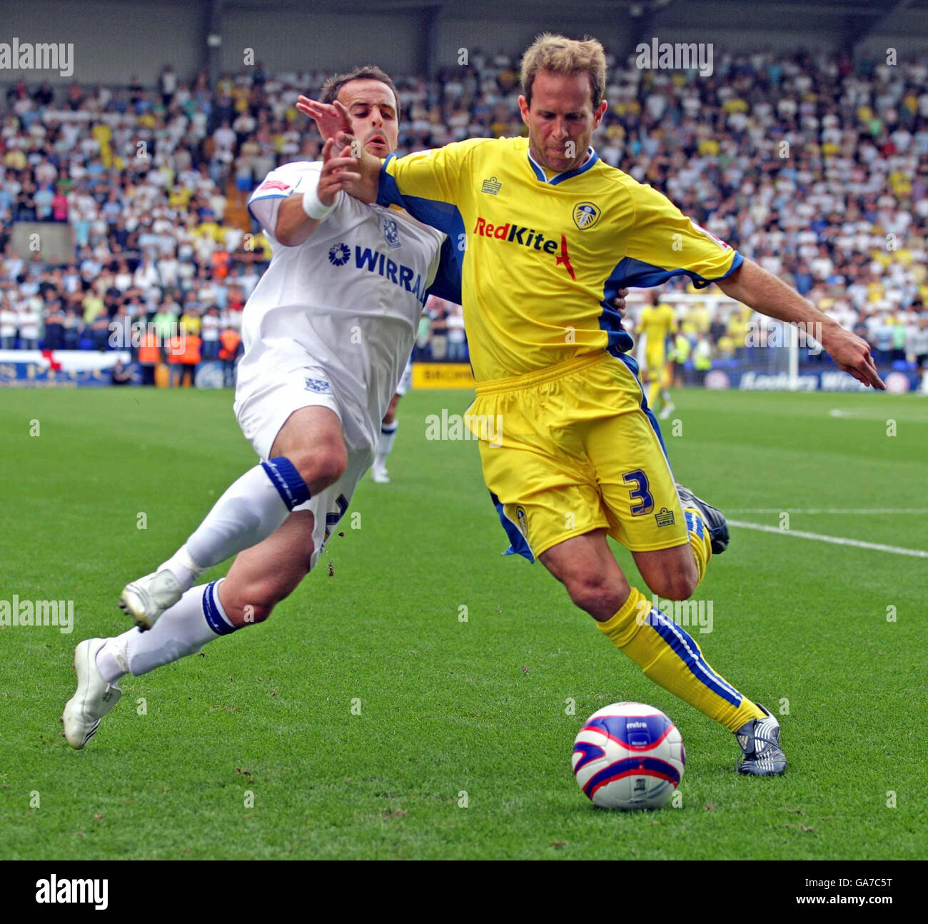 Eddie Lewis di Leeds (a destra) libera la palla sotto la pressione di Chris Shuker di Tranmere durante la partita della Coca-Cola Football League 1 al Prenton Park, Birkenhead. Foto Stock