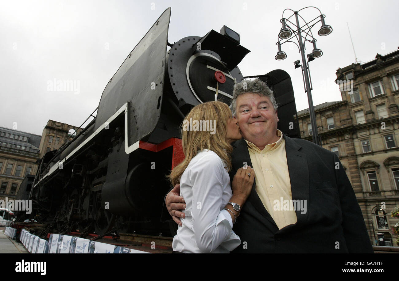 Carol Smillie dà un bacio alla star hollywoodiana Robbie Coltrane mentre assistono al ritorno di uno storico motore a vapore scozzese nella città di Glasgow dopo 60 anni in Sudafrica, la cerimonia che si tiene a George Square è la più grande acquisizione mai realizzata dai Musei di Glasgow. Foto Stock