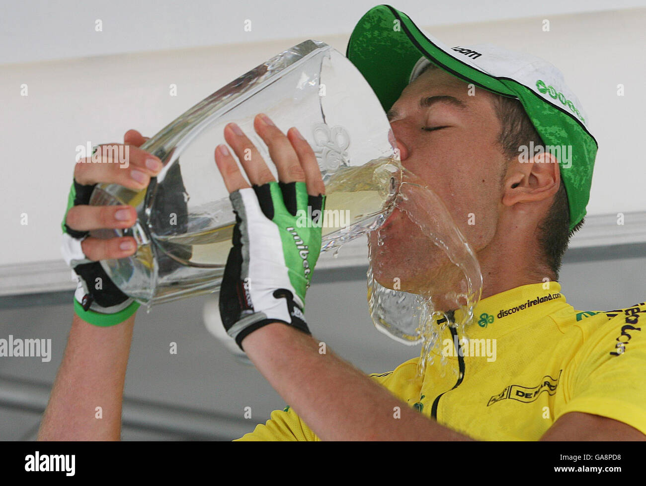 Stijn Vandengbergh, vincitore del primo Tour of Ireland cycle race, beve champagne dal suo trofeo dopo un'estenuante tappa finale da Athlone a Dublino. Foto Stock