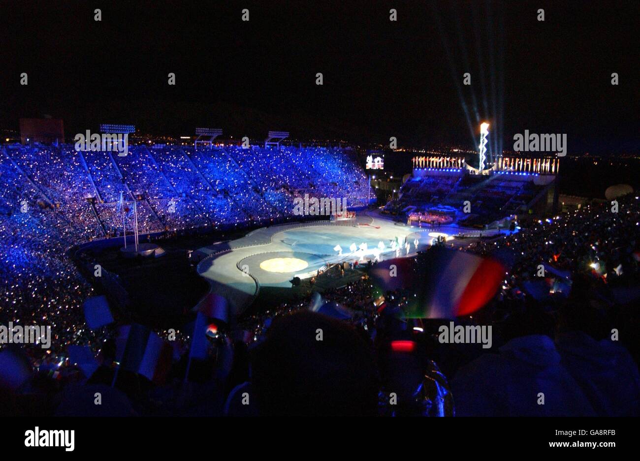 Olimpiadi invernali - Salt Lake City 2002 - cerimonia di chiusura. Un fan ondeggia la sede della bandiera italiana dei prossimi Giochi Olimpici invernali di Torino nel 2006 Foto Stock