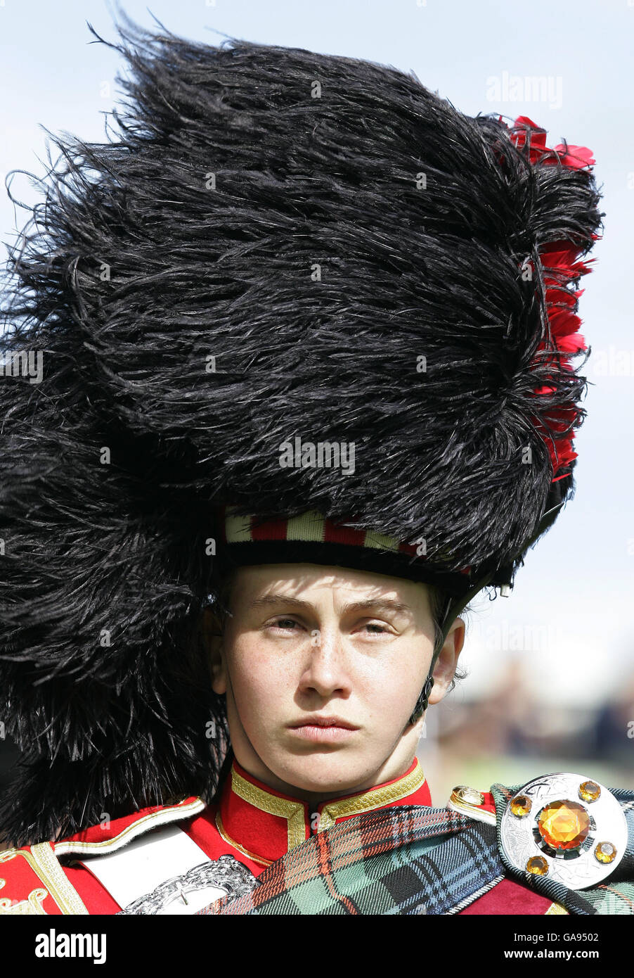 Wind prende il cappello di un membro della band durante il raduno delle Highland reali a Braemar. Foto Stock
