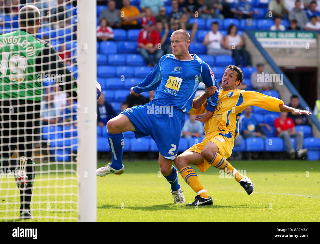 Josh Low di Peterborough United segna l'obiettivo di apertura sotto pressione Da Mansfield Town's Gareth Jelleyman Foto Stock