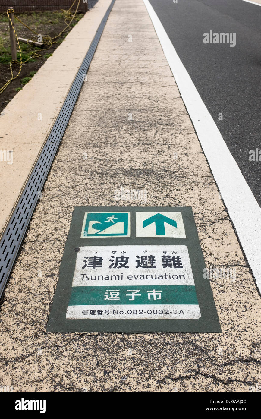 Un segno sulla strada indica un tsunami i percorsi di evacuazione in Zushi city, Giappone Foto Stock