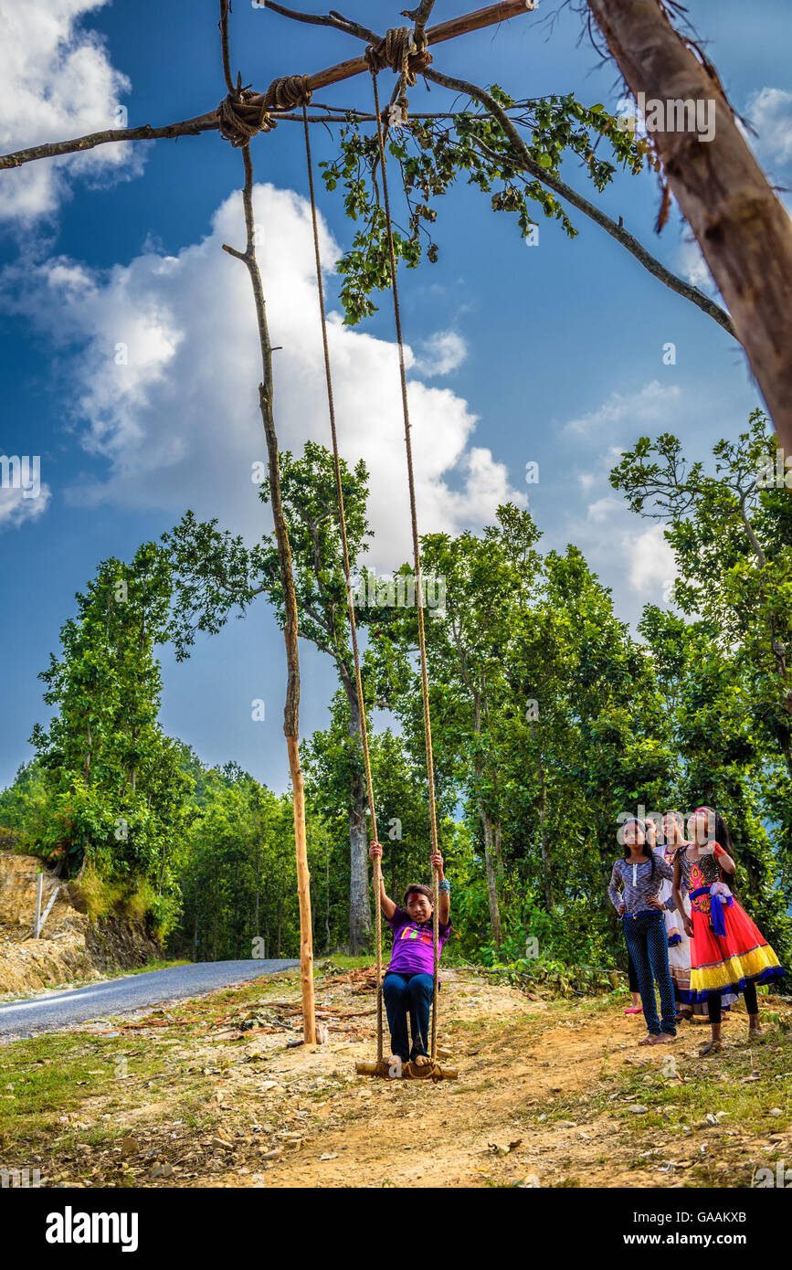 Ragazza nepalese giocando su un tradizionale swing di bambù chiamato linge ping. Foto Stock