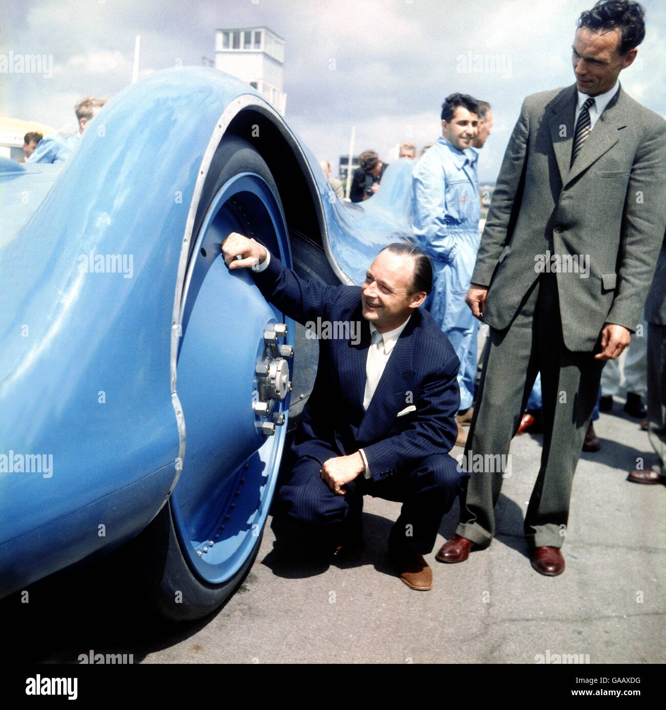 Donald Campbell esamina una delle ruote del suo nuovo Bluebird CN7/62, in cui doveva rompere il World Land Speed Record nel 1964. Foto Stock