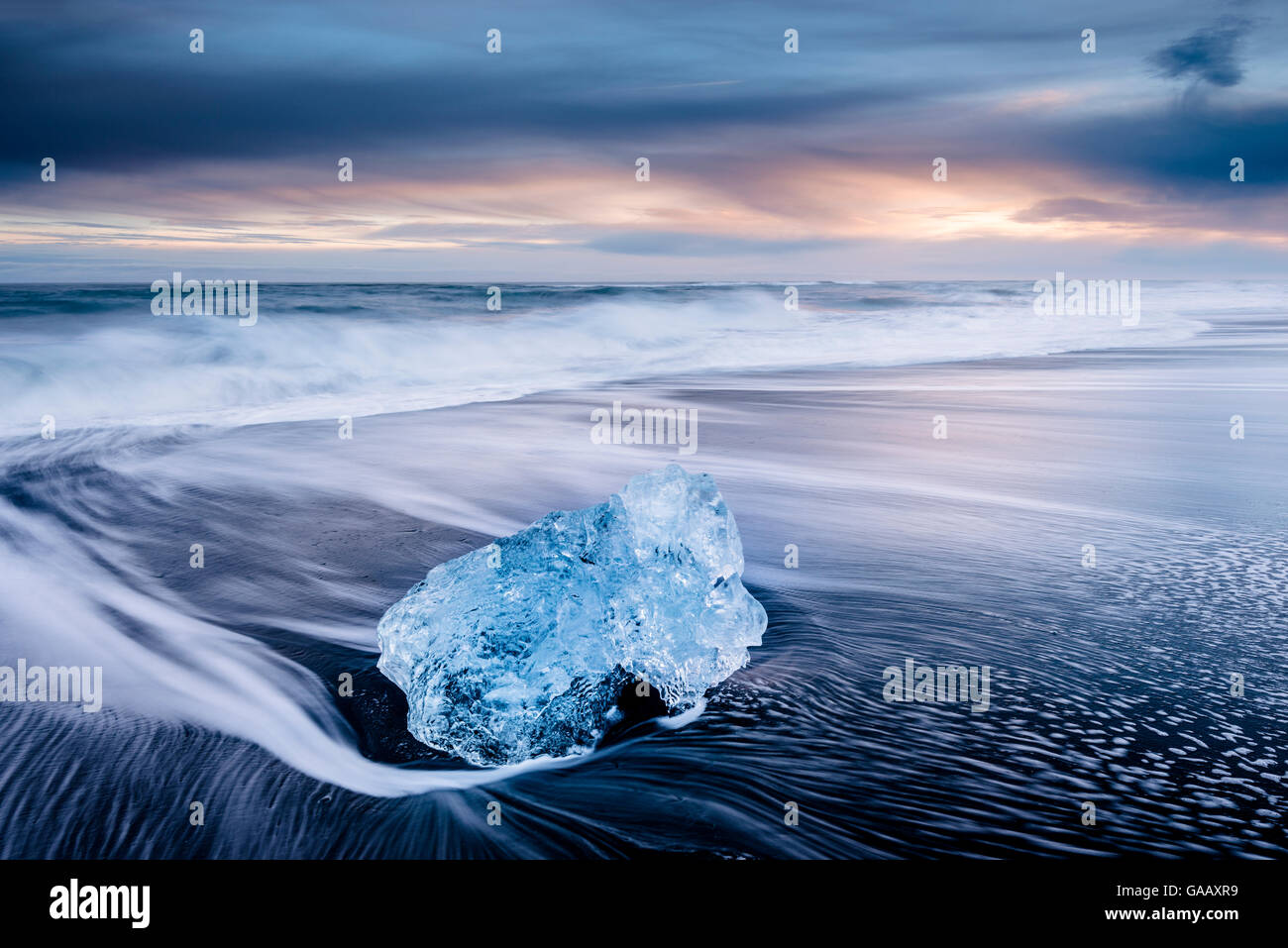 Ghiaccio sulla sabbia nera vulcanica spiaggia con onde, Jokulsarlon, sud-est di Islanda, febbraio. Foto Stock