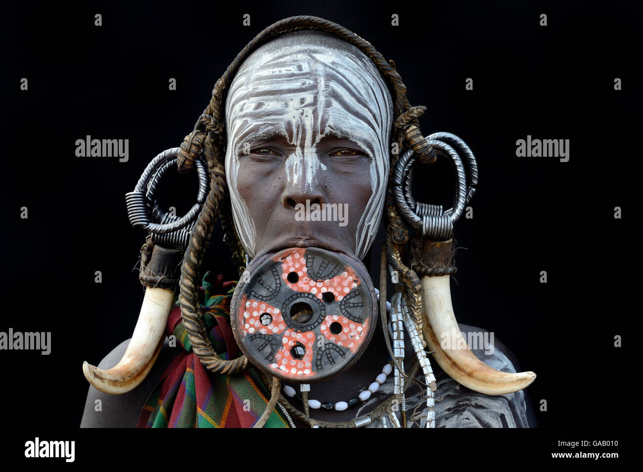 Ritratto di una donna dalla tribù dei Mursi, tradizionalmente decorate e dipinte, indossando un grande labbro di argilla piastra, Valle dell'Omo, Etiopia, marzo 2015. Foto Stock